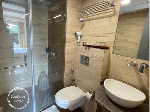 a bathroom with a shower and a toilet and a sink at Saltstayz Sector 39- Near Rajiv Chowk & Sohna Road in Gurgaon
