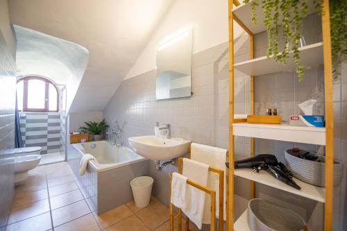 Giolitti 39 - Moderna Mansarda nel cuore di Torino في تورينو: حمام أبيض مع حوض ومرحاض