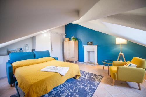 1 dormitorio con 1 cama amarilla y 2 sillas en Giolitti 39 - Moderna Mansarda nel cuore di Torino, en Turín