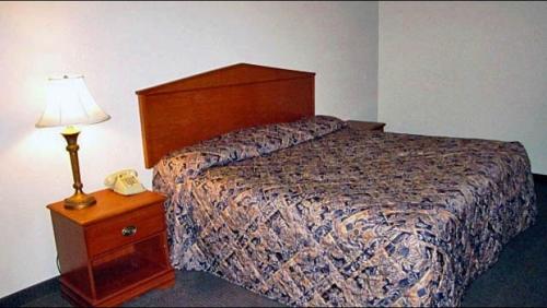 a bedroom with a bed and a nightstand with a phone at Studio 7 Harker Heights in Harker Heights