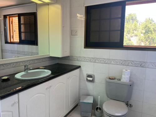 ein Badezimmer mit einem Waschbecken, einem WC und einem Spiegel in der Unterkunft VILLA AURA by AgroHolidays in Platres