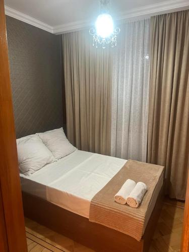 a bedroom with a bed with two towels on it at Apartment George in Kutaisi