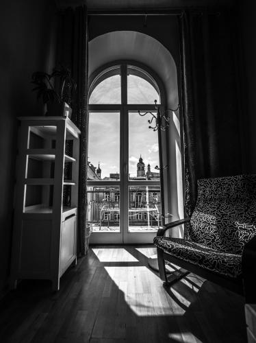 a room with a chair and a window with a view at Hostel Pod Basztą in Lublin