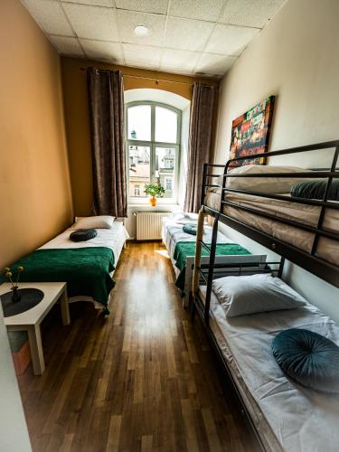 a room with three bunk beds and a window at Hostel Pod Basztą in Lublin
