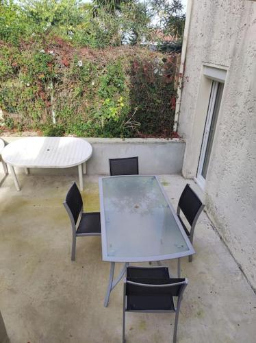 une table, des chaises, une table, une table et des chaises dans l'établissement Maison vue sur le bassin, proche du centre ville, à Arcachon