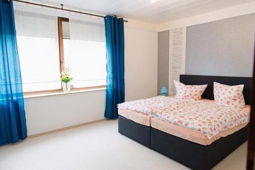 a bedroom with a bed with blue curtains at StockerHenke in Soltau