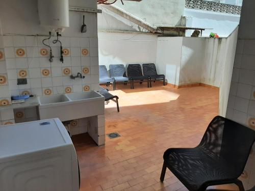 eine Küche mit einem Waschbecken und Stühlen in einem Zimmer in der Unterkunft Piso en Paseo Germanias in Gandía