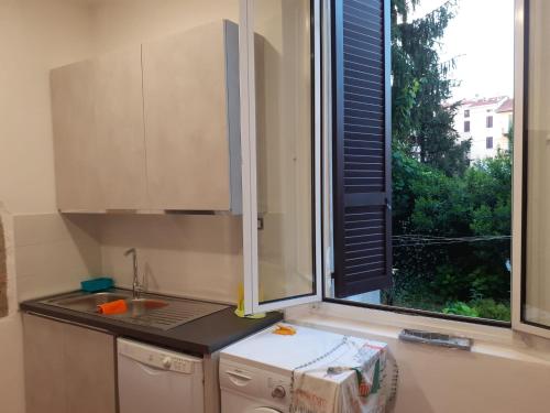 cocina con ventana, fregadero y fogones en A casa da Pier, en Parma
