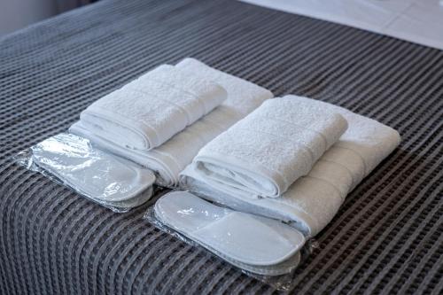 drie handdoeken en plastic containers op een tafel bij Maison Poème - Luxury Apartments in Aiándion