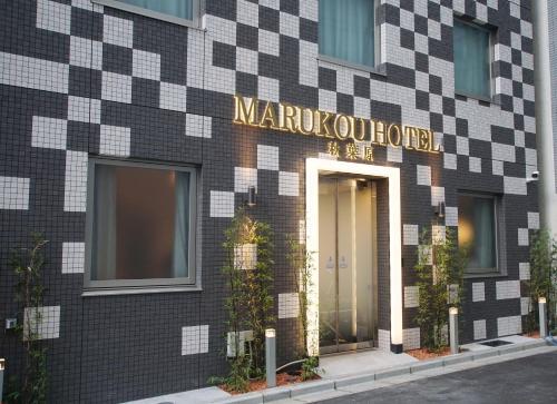 a building with a sign on the front of it at MARUKOU HOTEL in Tokyo