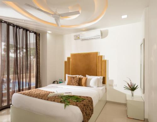 a bedroom with a large bed and a ceiling at Denver Villa in Lonavala