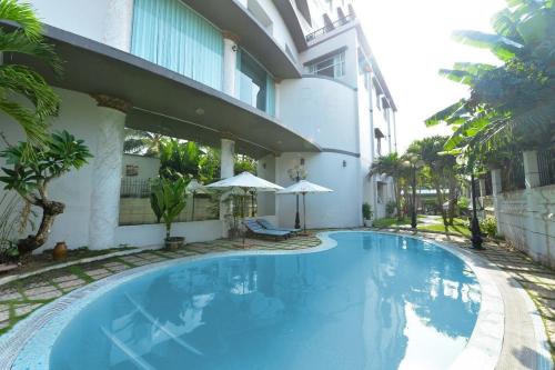 a large blue swimming pool next to a building at Hoa Binh 1 Hotel in Long Xuyên