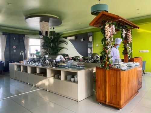 a kitchen with a chef preparing food in a restaurant at Hoa Binh 1 Hotel in Long Xuyên