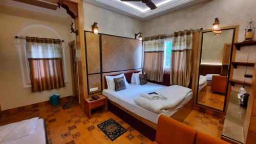 Hotel Temple On Ganges في فاراناسي: غرفة نوم فيها سرير ومرآة