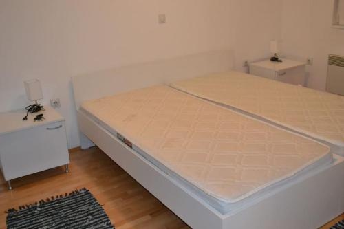 a bed in a room with two tables and a mattress at Panoramic View Skopje Apartments in Skopje