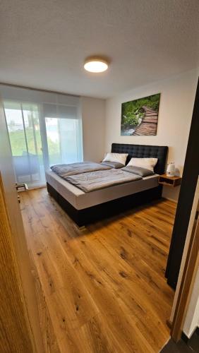 ein Schlafzimmer mit einem großen Bett und Holzboden in der Unterkunft Ferienwohnung im Glockenziel in Engen