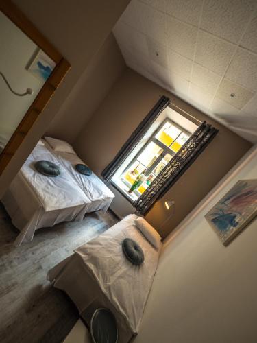 an attic room with two beds and a mirror at Hostel Pod Basztą in Lublin