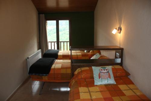 ein Schlafzimmer mit zwei Betten und einem Fenster in der Unterkunft Cal Rosetó in Aransá