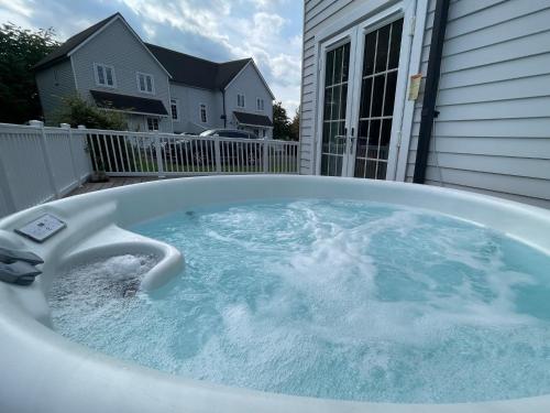 a jacuzzi tub in the backyard of a house at Windrush Turret Lodge in South Cerney