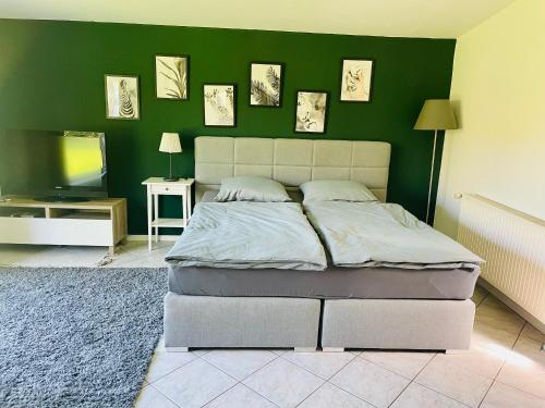 a bedroom with a bed and a green wall at Sanders Ferienhaus in Winsen Aller