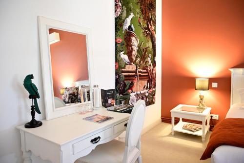 a bedroom with a desk with a mirror and a bed at Pavillon des Millésimes, Piscine & SPA in Lussac