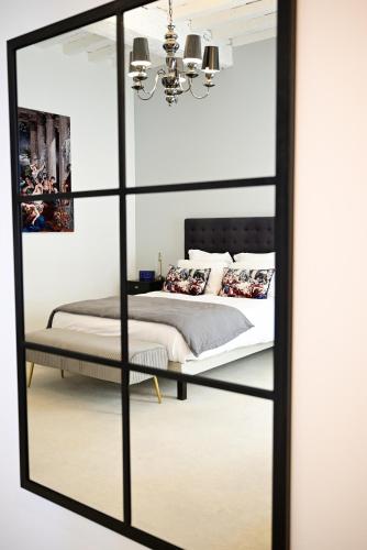 a mirror in a bedroom with a bed at Pavillon des Millésimes, Piscine & SPA in Lussac