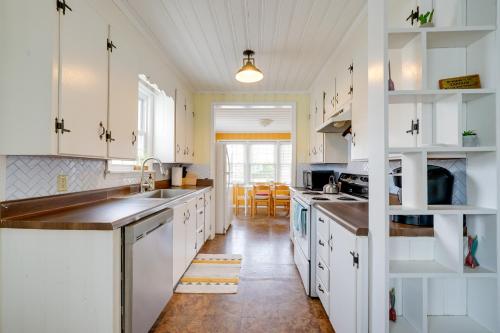 a kitchen with white cabinets and a wooden floor at Carolina Beach Home with Private Deck Walk to Shore in Carolina Beach