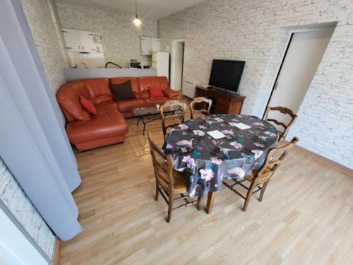 sala de estar con mesa, sillas y sofá en Gîte43, en Decazeville