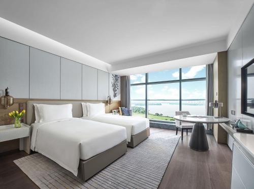 Habitación de hotel con 2 camas y mesa en Cordis, Xuzhou, en Xuzhou