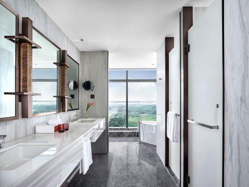 a bathroom with two sinks and a large window at Cordis, Xuzhou in Xuzhou