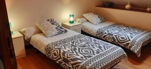 zwei Betten nebeneinander in einem Zimmer in der Unterkunft Les Roses Trémières in Trans