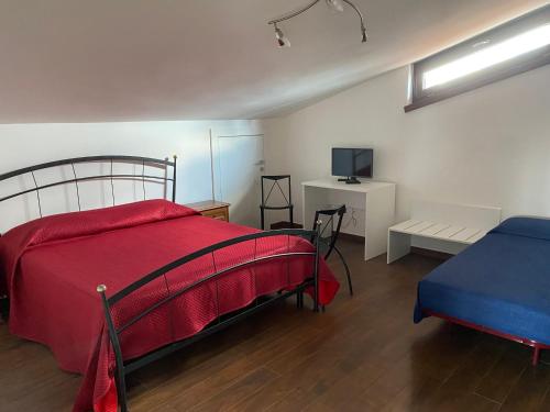 1 dormitorio con 1 cama con manta roja y TV en Il sospiro, en Satriano di Lucania
