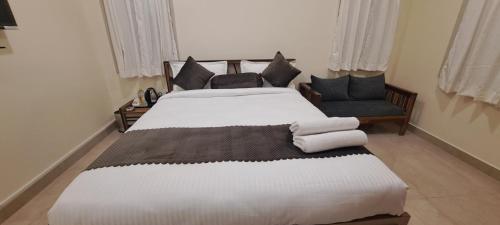 a bedroom with two beds and a chair at The Candy Studio in Rānchī
