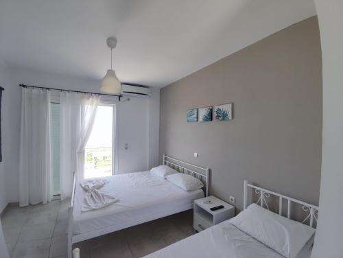 a bedroom with two beds and a window at Penelope & Michael Rooms in Himare