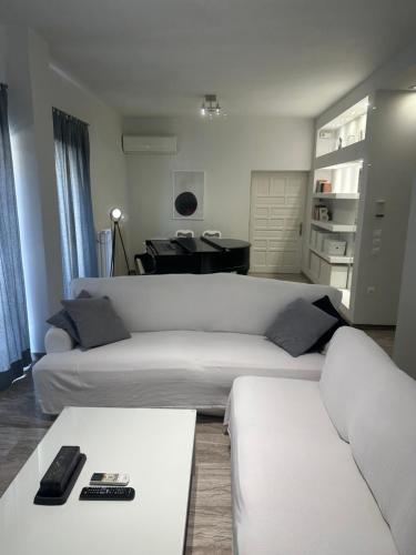 a living room with two white couches and a table at Casa di Giorgio in Nafpaktos