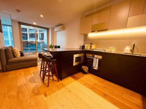 a kitchen with a counter and a couch in a room at Nest Apartments on Rose Lane in Melbourne