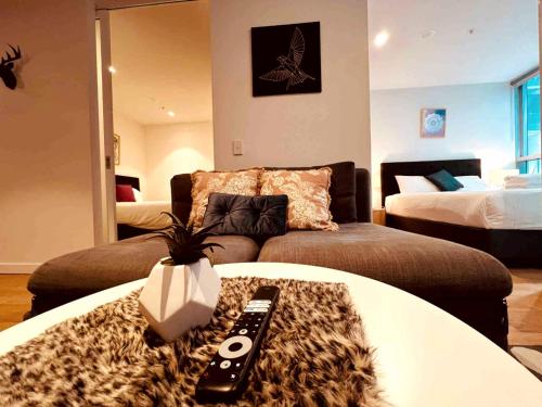 a room with a couch and a table with a remote control at Nest Apartments on Rose Lane in Melbourne