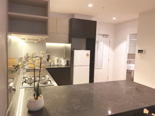 a kitchen with a black counter top and a refrigerator at Nest Apartments on Rose Lane in Melbourne