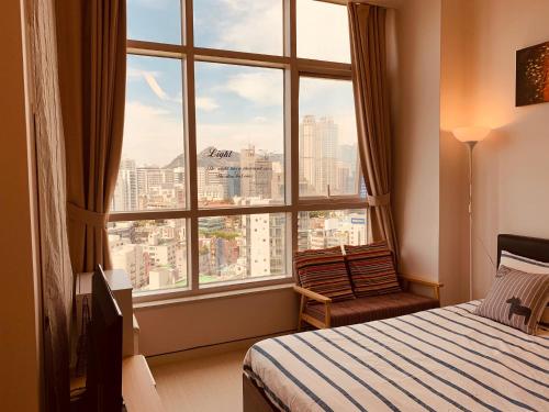 a bedroom with a large window with a view of a city at Travel House in Seoul