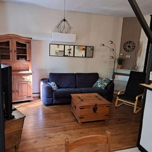 a living room with a blue couch and a coffee table at Location gîte à Jaujac in Jaujac