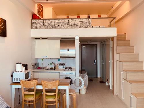 a small kitchen with a dining table and a loft bed at Travel House in Seoul