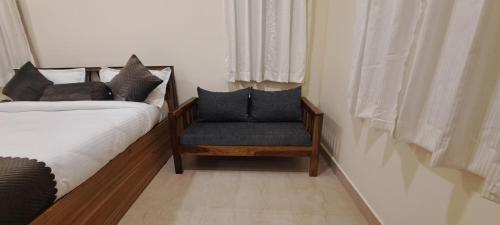 a bedroom with a bed and a chair with pillows at The Candy Studio in Rānchī