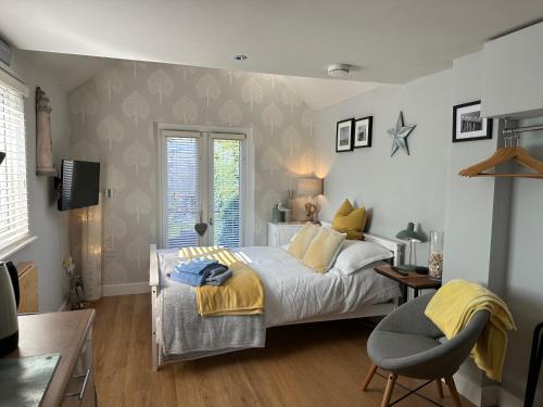 een slaapkamer met een bed, een bureau en een stoel bij The Annexe in Waltham