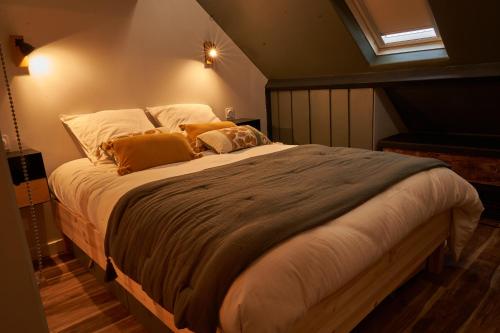 Un dormitorio con una cama grande con almohadas. en Gîte de Bonneville en Nantes