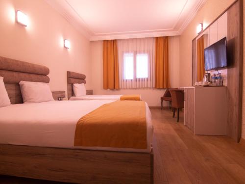 a hotel room with a bed and a flat screen tv at Anatolia Park Hotel in Kayseri