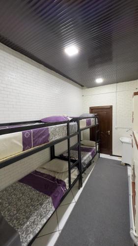 a room with three bunk beds in it at Shinam Hostel in Chilanzar