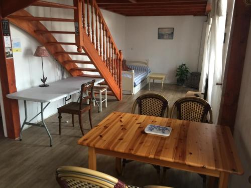 een eetkamer met een tafel en stoelen en een trap bij Appartement côte des basques in Biarritz