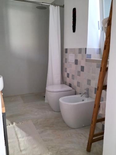 a bathroom with a toilet and a tub and a sink at Casa Giufà B&B in Chiaramonte Gulfi