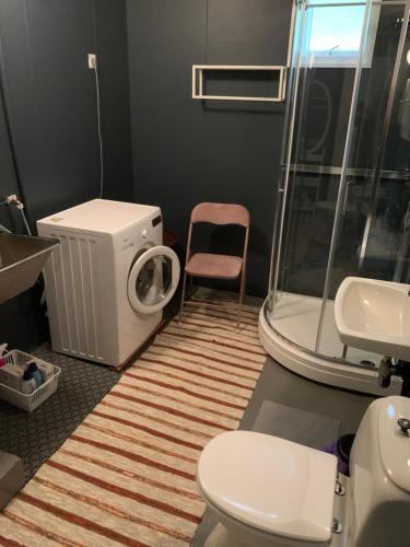 a bathroom with a washing machine and a washer at Liten leilighet med to soverom in Valberg