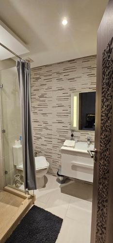 a bathroom with a sink and a toilet and a mirror at family apartment with swimming pool air conditionning and elevator in Marrakech